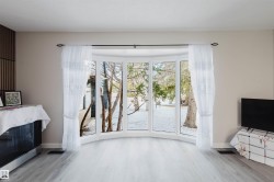 Unfurnished living room featuring baseboards and light wood finished floors - 