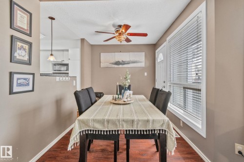 Dining area with dark wood-style floors, a ceiling fan, and a textured ceiling - 3 1820 56 Street, Edmonton, AB - Indoor Photo Showing Dining Room