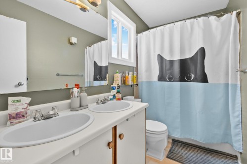 Bathroom with double vanity and shower / bath combo with shower curtain - 3 1820 56 Street, Edmonton, AB - Indoor Photo Showing Bathroom