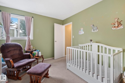 Carpeted bedroom featuring a crib and baseboards - 3 1820 56 Street, Edmonton, AB - Indoor Photo Showing Bedroom