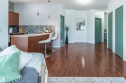 Kitchen with open floor plan, hanging light fixtures, wood finish cabinets, a peninsula, and a kitchen bar - 