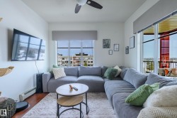 Living area featuring a baseboard heating unit, wood finished floors, and a ceiling fan - 