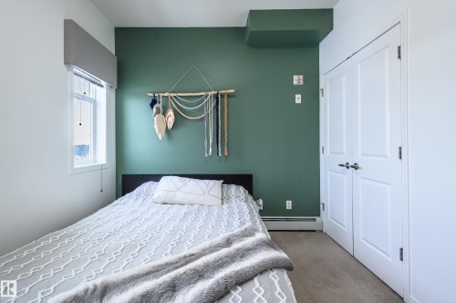 Carpeted bedroom featuring a baseboard radiator and a closet - 411 1619 James Mowatt Trail, Edmonton, AB - Indoor Photo Showing Bedroom