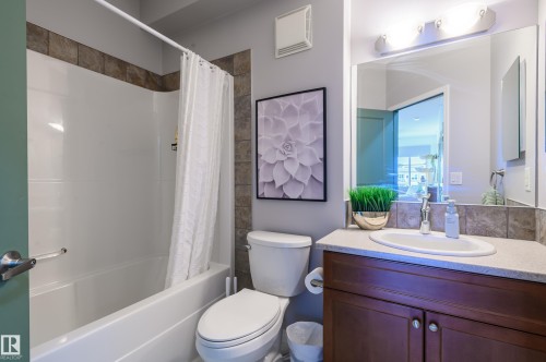 Full bath with vanity and shower / bath combo with shower curtain - 411 1619 James Mowatt Trail, Edmonton, AB - Indoor Photo Showing Bathroom