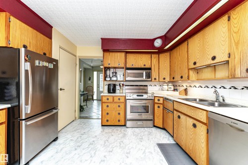 Kitchen with stainless steel appliances, light countertops, and wood finish cabinets - 2112 67 Street Nw, Edmonton, AB - Indoor Photo Showing Kitchen With Double Sink