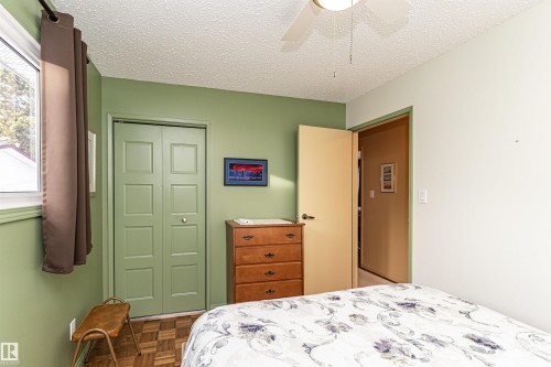 Bedroom with a textured ceiling, parquet floors, a ceiling fan, and a closet - 2112 67 Street Nw, Edmonton, AB - Indoor Photo Showing Bedroom