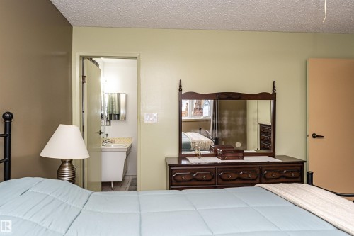 Bedroom with a textured ceiling and ensuite bath - 2112 67 Street Nw, Edmonton, AB - Indoor Photo Showing Bedroom