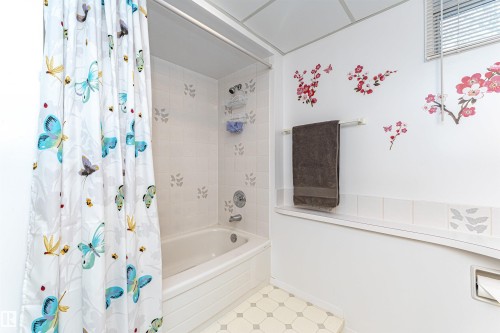 Bathroom with shower / tub combo with curtain and tile patterned floors - 2112 67 Street Nw, Edmonton, AB - Indoor Photo Showing Bathroom
