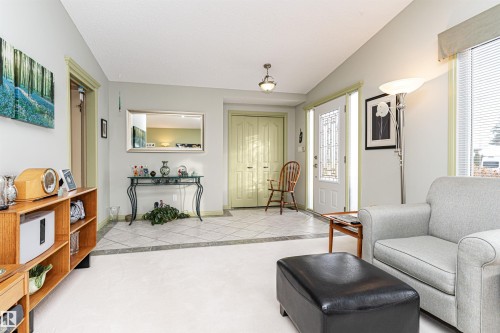 Living area with light tile patterned floors, lofted ceiling, and plenty of natural light - 2112 67 Street Nw, Edmonton, AB - Indoor Photo Showing Living Room