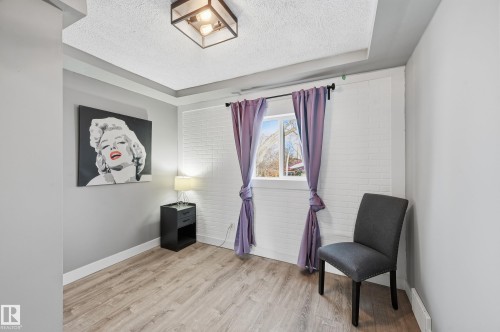 Sitting room with light wood finished floors and a textured ceiling - 10656 93 Street, Edmonton, AB - Indoor