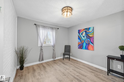 Living area with light wood-style flooring and a textured ceiling - 10656 93 Street, Edmonton, AB - Indoor Photo Showing Other Room