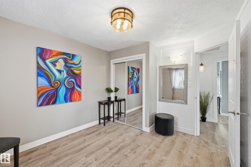 Entrance foyer with light wood-type flooring and a textured ceiling - 10656 93 Street, Edmonton, AB - Indoor Photo Showing Other Room