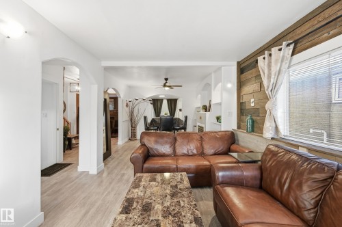 Living room featuring light wood finished floors, arched walkways, and a ceiling fan - 10656 93 Street, Edmonton, AB - Indoor Photo Showing Living Room