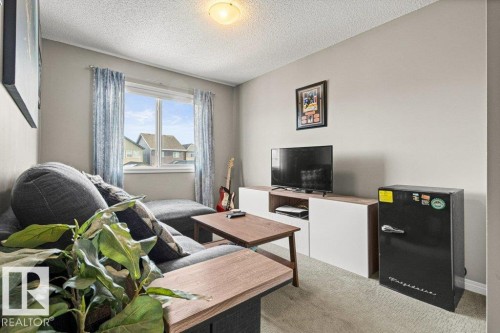 Carpeted living area with a textured ceiling - 3351 Orchards Link, Edmonton, AB - Indoor