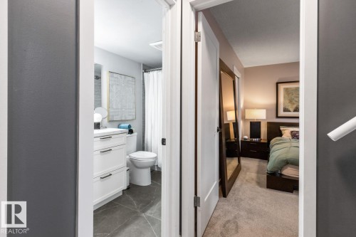 Full bath featuring a shower with shower curtain, connected bathroom, vanity, and light carpet - 6411 180 Street, Edmonton, AB - Indoor Photo Showing Other Room