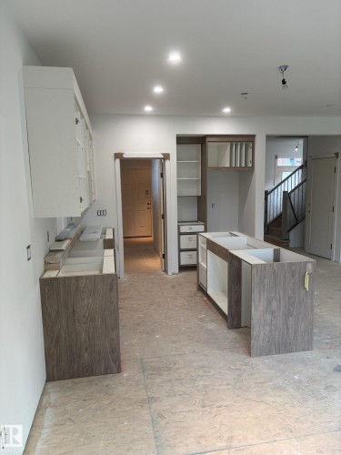 Kitchen cabinetry installation featuring contemporary wood-finish lower cabinets and white upper cabinets - 30 Elsinore Place, Edmonton, AB - Indoor