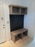 Built-in entryway bench with wood-finish construction, integrated storage cubbies, and a black paneled backboard with five hooks - 30 Elsinore Place, Edmonton, AB 