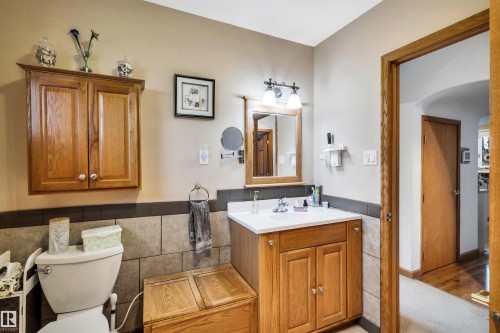 Half bathroom with vanity, tile walls, and wainscoting - 11432 71 Street, Edmonton, AB - Indoor Photo Showing Bathroom