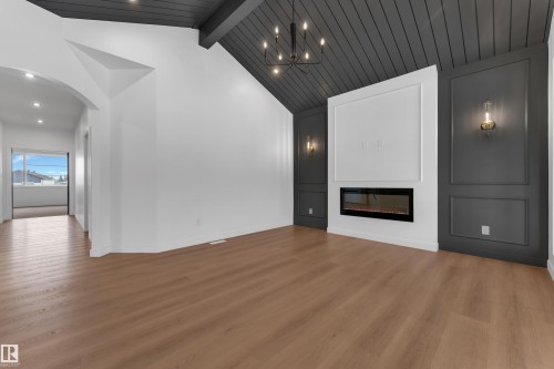 Unfurnished living room featuring wood finished floors, a glass covered fireplace, arched walkways, and recessed lighting - 40 Grayson Green, Stony Plain, AB - Indoor With Fireplace