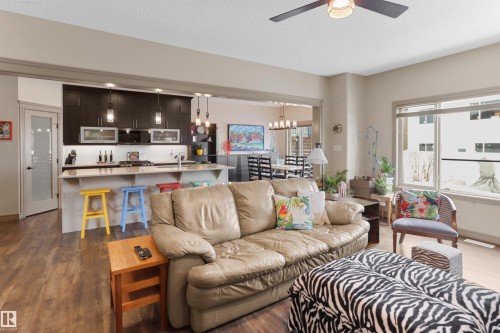 Living area with dark wood-style flooring, ceiling fan, a textured ceiling, and suspended lighting - 97 Astoria Point(E), Devon, AB - Indoor Photo Showing Living Room