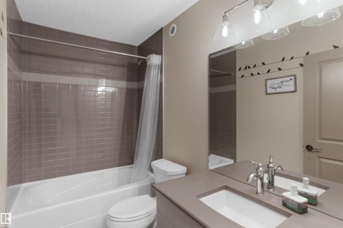 Full bath with shower / bath combination with curtain, vanity, and a textured ceiling - 97 Astoria Point(E), Devon, AB - Indoor Photo Showing Bathroom