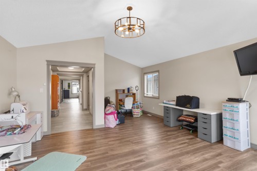 Home office with light wood-style flooring, vaulted ceiling, and hanging lights - 97 Astoria Point(E), Devon, AB - Indoor
