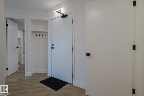 Foyer with light wood vinyl plank flooring and baseboards - 505 10149 Saskatchewan Drive, Edmonton, AB - Indoor Photo Showing Other Room