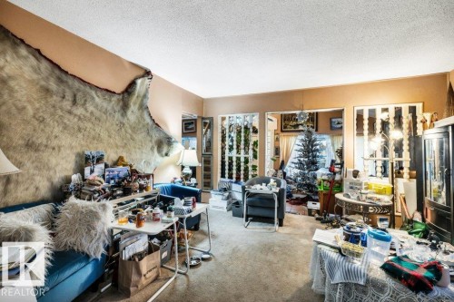 Carpeted living area with a textured ceiling - 11436 71 Street, Edmonton, AB - Indoor