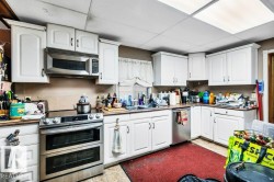 Kitchen with stainless steel appliances and white cabinets - 