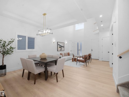 Dining room featuring light wood-style flooring, a raised ceiling, and suspended lighting - 1168 Gyrfalcon Crescent, Edmonton, AB - Indoor Photo Showing Dining Room