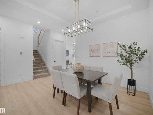 Dining space with light wood-style flooring and suspended lighting - 1168 Gyrfalcon Crescent, Edmonton, AB - Indoor Photo Showing Dining Room