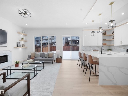 Living room with light wood-style flooring, recessed lighting, and a high end fireplace - 1168 Gyrfalcon Crescent, Edmonton, AB - Indoor With Fireplace