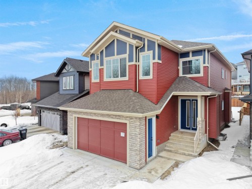 View of front facade with roof with shingles, an attached garage, and stone siding - 1168 Gyrfalcon Crescent, Edmonton, AB - Outdoor With Exterior