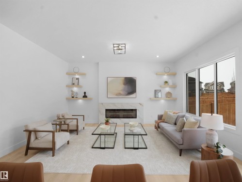 Living room featuring a fireplace and light wood-style flooring - 1168 Gyrfalcon Crescent, Edmonton, AB - Indoor Photo Showing Living Room With Fireplace