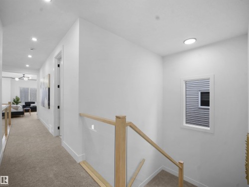 Hallway with an upstairs landing, light carpet, and recessed lighting - 1168 Gyrfalcon Crescent, Edmonton, AB - Indoor Photo Showing Other Room