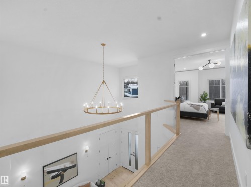 Hallway with a chandelier and carpet floors - 1168 Gyrfalcon Crescent, Edmonton, AB - Indoor Photo Showing Other Room