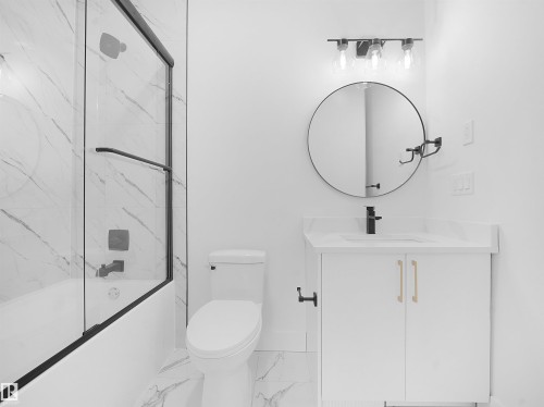 Full bath featuring enclosed tub / shower combo, vanity, and marble finish flooring - 1168 Gyrfalcon Crescent, Edmonton, AB - Indoor Photo Showing Bathroom