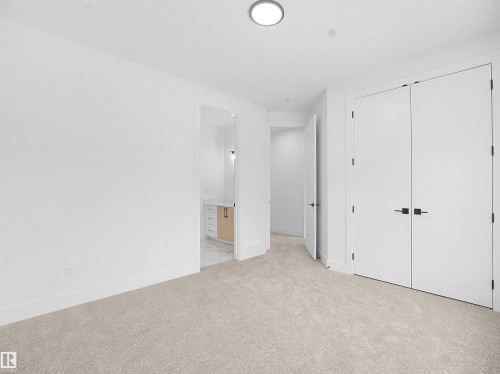 Unfurnished bedroom with light colored carpet, a closet, and connected bathroom - 1168 Gyrfalcon Crescent, Edmonton, AB - Indoor Photo Showing Other Room