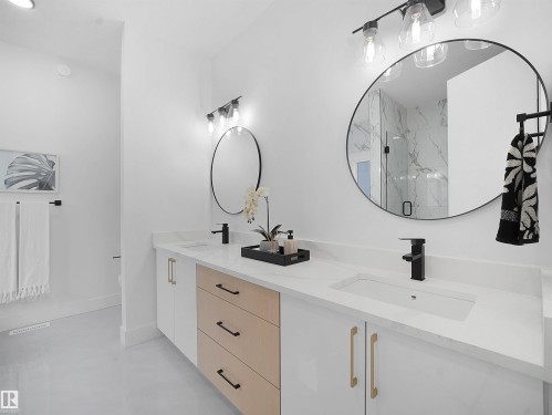 Bathroom with double vanity, a marble finish shower, and concrete flooring - 1168 Gyrfalcon Crescent, Edmonton, AB - Indoor Photo Showing Bathroom