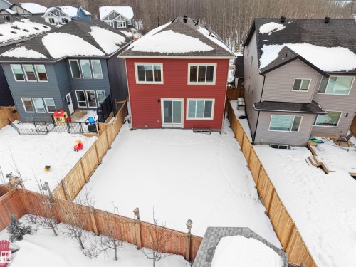Snow covered house with a fenced backyard, a wooden deck, and a residential view - 1168 Gyrfalcon Crescent, Edmonton, AB - Outdoor