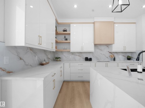 Kitchen with modern cabinets, white cabinetry, open shelves, light stone counters, and light wood-style flooring - 1168 Gyrfalcon Crescent, Edmonton, AB - Indoor Photo Showing Kitchen
