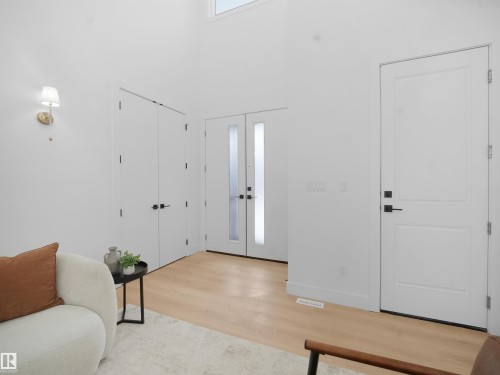 Foyer entrance with light wood-style flooring, a high ceiling, and french doors - 1168 Gyrfalcon Crescent, Edmonton, AB - Indoor Photo Showing Other Room