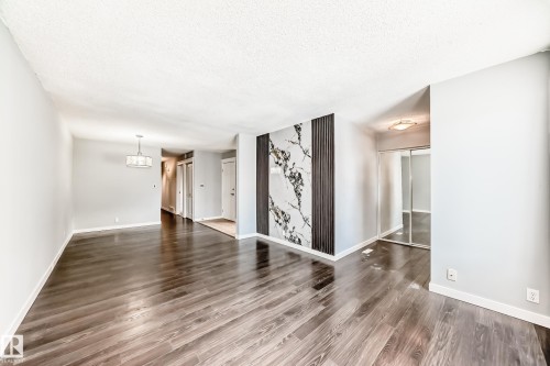 Unfurnished living room with a textured ceiling and dark wood-type flooring - 10331 153 Street, Edmonton, AB - Indoor Photo Showing Other Room