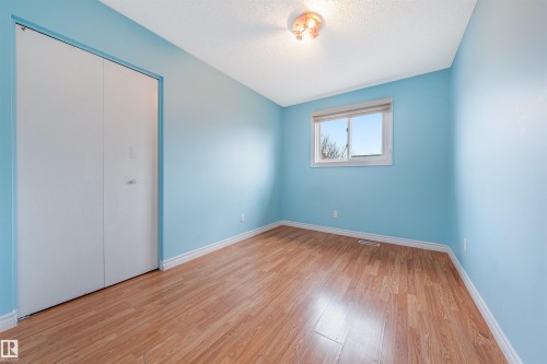 Unfurnished bedroom featuring a closet, light wood-style floors, and a textured ceiling - 2831 36 Street, Edmonton, AB - Indoor Photo Showing Other Room