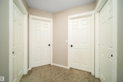 Hallway featuring a textured ceiling and carpet flooring - 