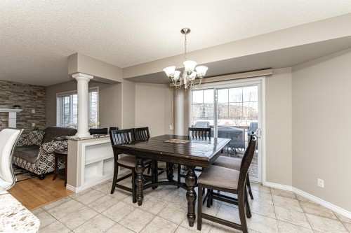 Dining area with a textured ceiling, suspended lighting, and light tile patterned flooring - 192 Keyport Circle, Leduc, AB - Indoor Photo Showing Dining Room
