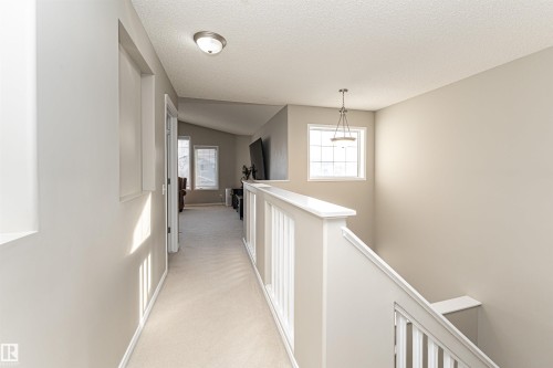 Corridor with light carpet and an upstairs landing - 192 Keyport Circle, Leduc, AB - Indoor Photo Showing Other Room