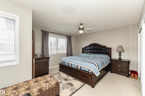 Bedroom with light carpet, a textured ceiling, and ceiling fan - 192 Keyport Circle, Leduc, AB - Indoor Photo Showing Bedroom