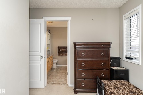 Bedroom featuring ensuite bathroom and a textured ceiling - 192 Keyport Circle, Leduc, AB - Indoor