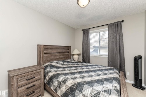 Bedroom with light colored carpet and a textured ceiling - 192 Keyport Circle, Leduc, AB - Indoor Photo Showing Bedroom